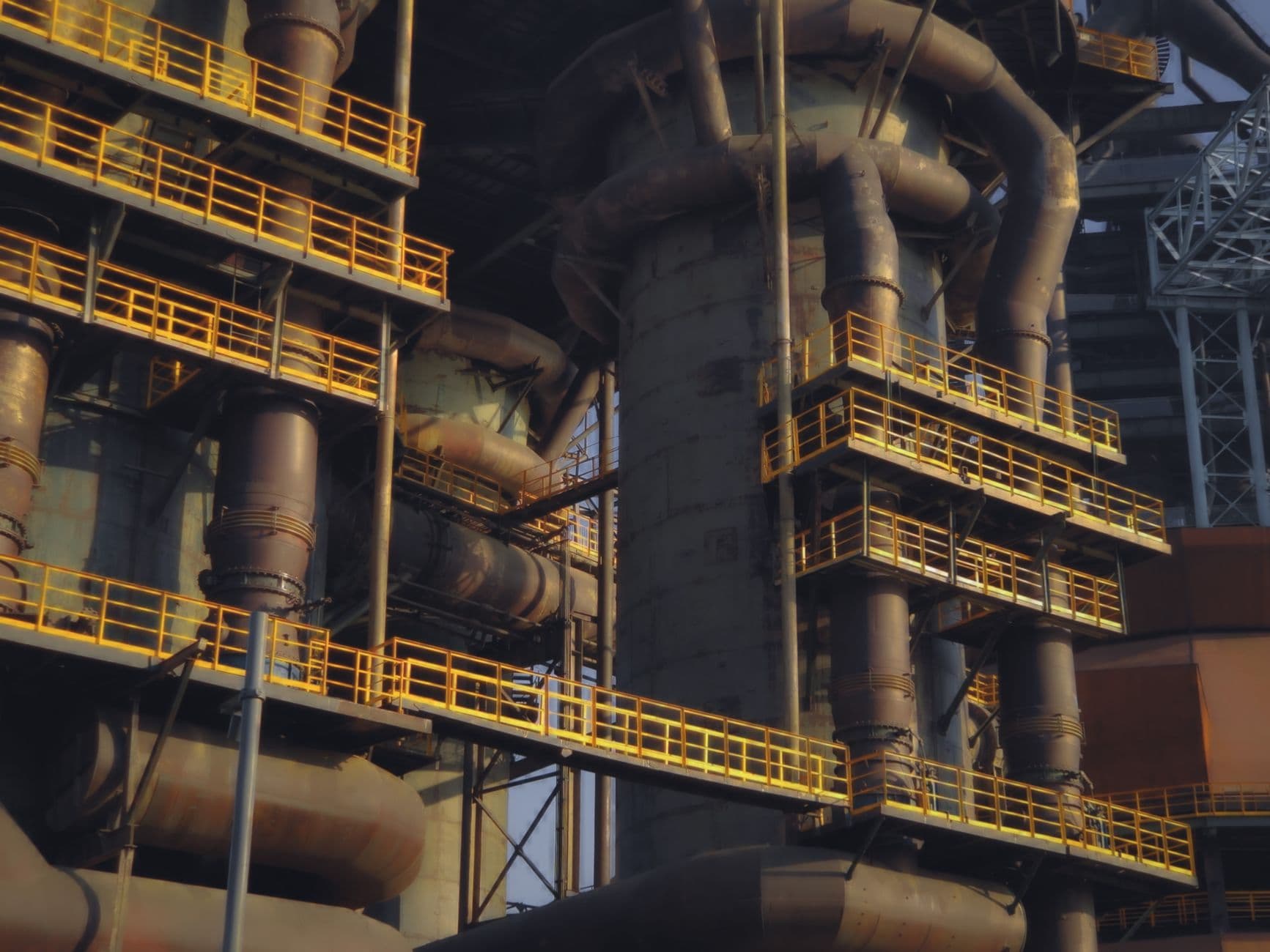 Vue aérienne d'une grande raffinerie chinoise avec colonnes de distillation, conduites et réservoirs de pétrole.