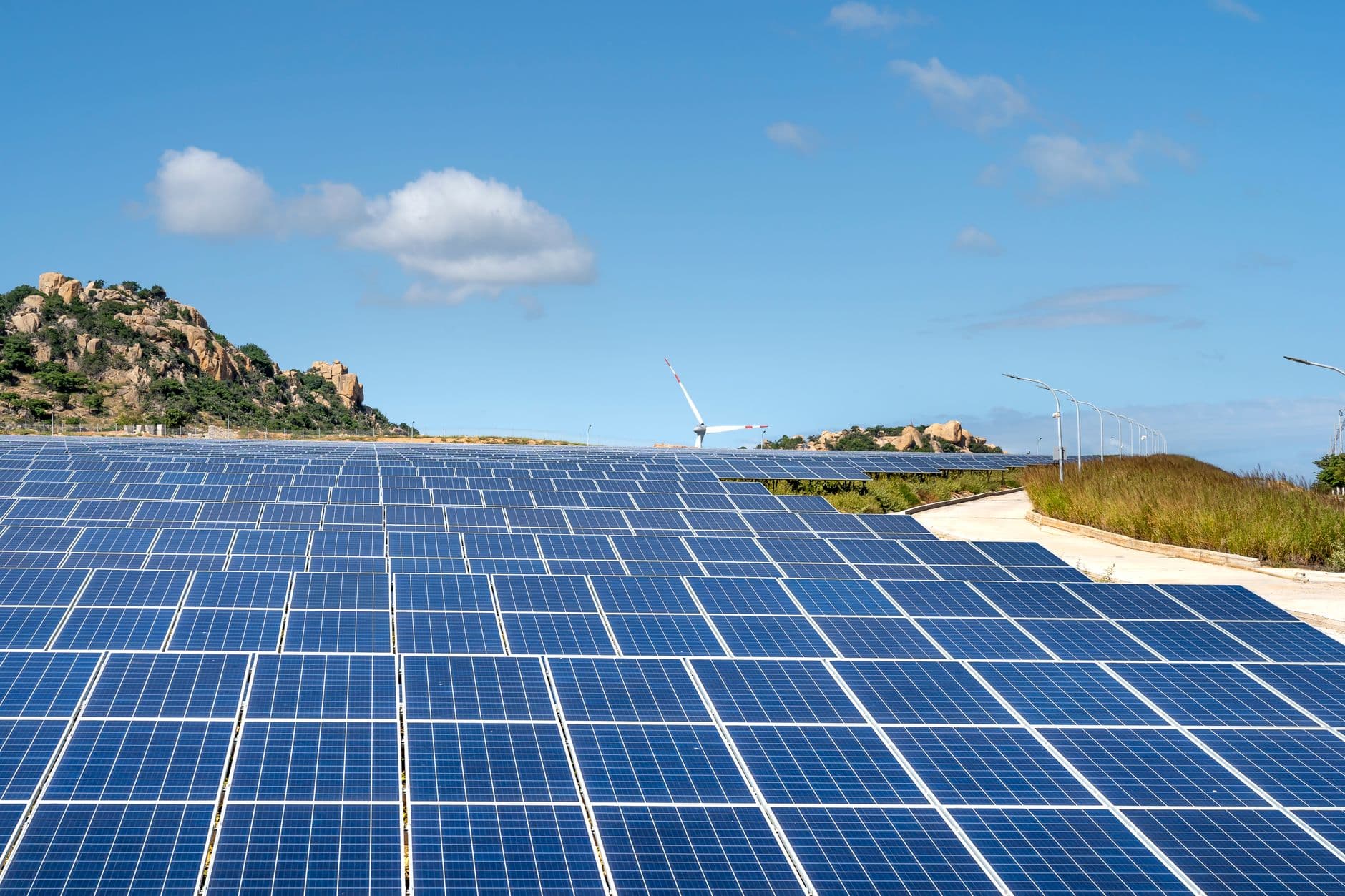 Vaste centrale solaire sur un plateau montagneux du Monténégro, près d'un réservoir.